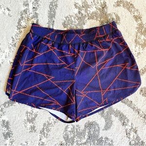 Dark purple athletic shorts with an orange pattern